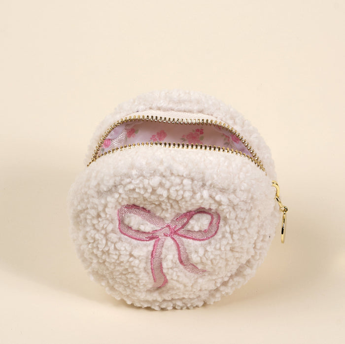The Circle Bow Pink Teddy Pouch by the-darling-effect is a soft sherpa coin purse featuring a white, fluffy round design, pink embroidered bow, and floral lining.