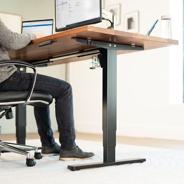 Heavy-duty sit or stand desk frame with adjustable height using touch screen control panel.