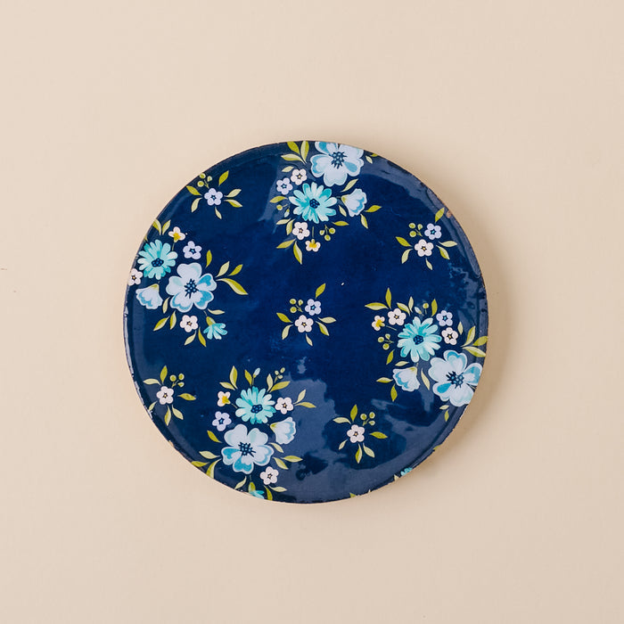 The Endless Daydream Navy Wood Enamel Coaster by the-darling-effect features a dark blue base with light blue and white floral designs, making it ideal for pairing with your favorite plates to elevate any tabletop style.