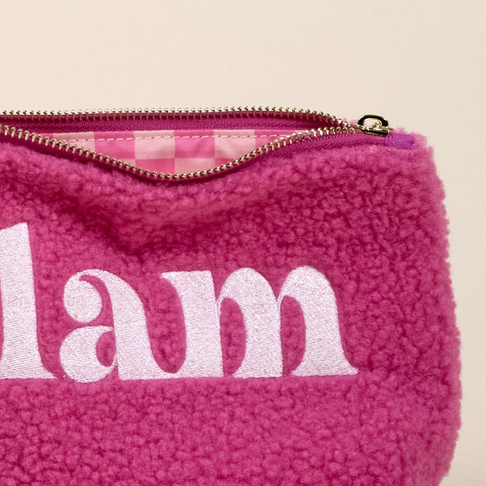 The Glam Teddy Pouch by the-darling-effect is a fuzzy pink sherpa pouch with "lam" embroidered on the front and a checkered interior—an adorable addition to your accessory collection.