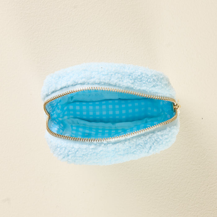 The Square Pearl Blue Teddy Pouch from the-darling-effect features a fluffy light blue exterior and an open zipper that reveals a charming blue checkered lining.