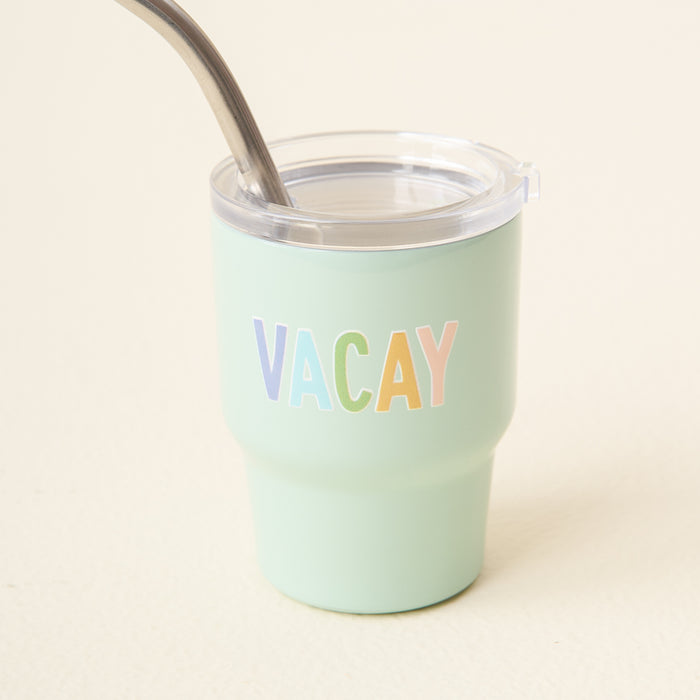 The-darling-effect's Vacay 2 oz Tiny Tumbler is mint green with a clear lid, metal straw, and features "VACAY" in pastel-colored letters on the front.