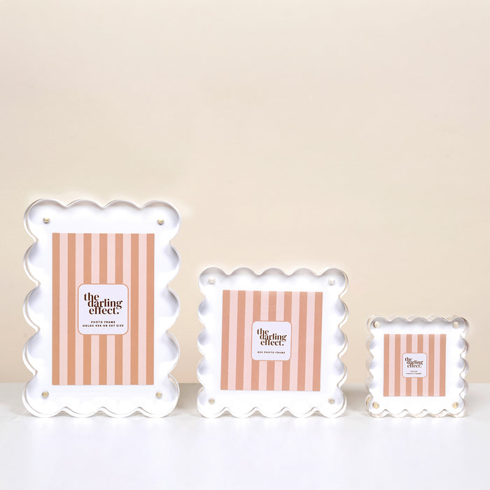 Three White Rectangle Scalloped Acrylic Frames by the-darling-effect, each with pink and white striped inserts, sit on a white surface against a cream background, bringing playful charm to modern décor.