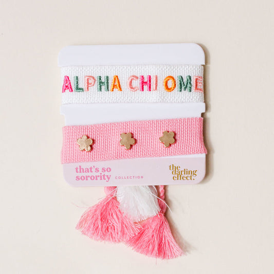 The Darling Effect Alpha Chi Omega Woven Bracelet Set features a white bracelet with ALPHA CHI OMEGA in colorful letters and a pink band with gold flower studs, pink/white tassels—an ideal sorority gift.
