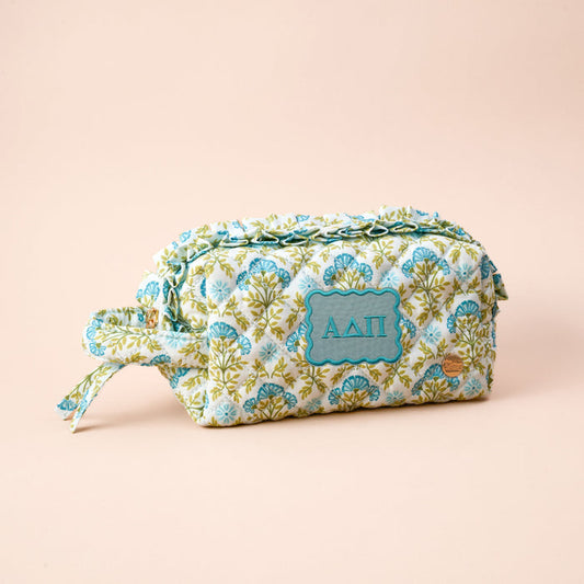 The Alpha Delta Pi Essentials Quilted Cosmetic Pouch by The Darling Effect is a floral-patterned, zippered pouch with side handle and blue ΑΔΠ patch—ideal for carrying your sorority essentials.