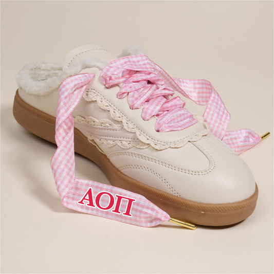 The Darling Effect's Alpha Omicron Pi Step It Up Shoelaces feature pink gingham laces with red ΑΟΠ embroidery—perfect cute sorority gifts. Cream slip-on style, brown sole, lace trim, and soft sherpa lining inside.