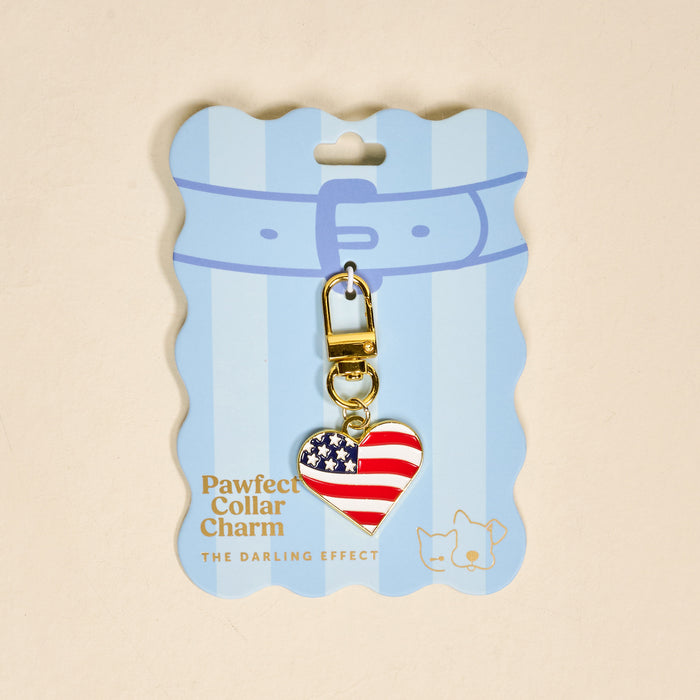 The Darling Effect Americana Heart Pawfect Collar Charm features a heart-shaped American flag design, gold clasp, and blue packaging with two pet illustrations—a patriotic accessory for your pet.
