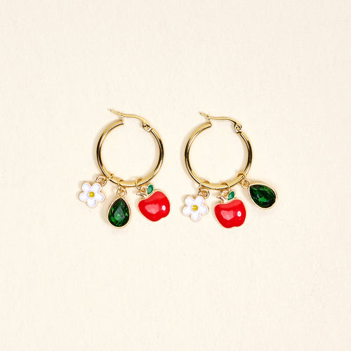 The Darling Effect’s Apple of My Eye Signature Hoop Earrings feature gold hoops with white flower, red apple, and green teardrop charms—playful jewelry for everyday wear, shown on a simple light background.