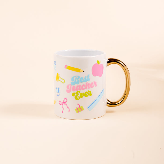 The Darling Effect's Best Teacher Ever 11 oz Cozy Cute Ceramic Mug features a gold handle and school-themed icons—a pink apple, yellow pencil, and ruler—making it the perfect gift for teachers to enjoy coffee or tea.