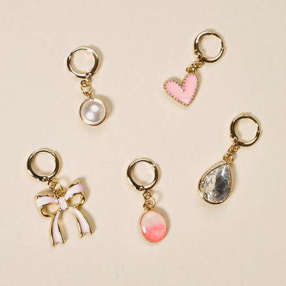 The Darling Effect’s Blush Crush The Ultimate Charm Pack features five gold keychain charms—a white pearl, pink heart, clear teardrop gem, pink and white bow, and a pink oval gem—perfect for scrunchie sets or statement necklaces.