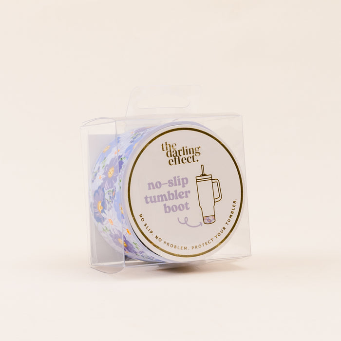 The Bouquet Beauty Purple Tumbler Silicone Boot by the-darling-effect comes in clear packaging labeled “no-slip tumbler boot,” with a cup and floral illustration, offering protection and helping to prevent tumbler dents.