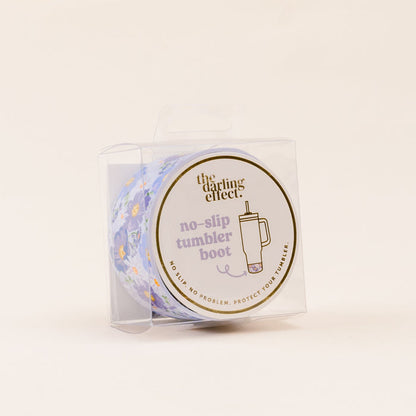 The Bouquet Beauty Purple Tumbler Silicone Boot by the-darling-effect comes in clear packaging labeled “no-slip tumbler boot,” with a cup and floral illustration, offering protection and helping to prevent tumbler dents.