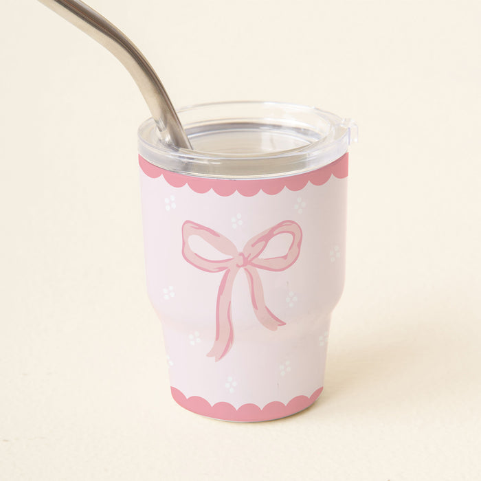 The Bow Pink 2 oz Tiny Tumbler by the-darling-effect is a cute pink and white mini tumbler with a clear lid, scalloped edges, pink ribbon, and stainless steel straw inside—ideal for travel or as an insulated shot glass.