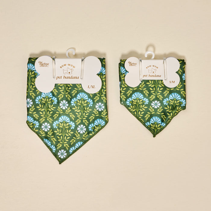 Two Bow-Wow Pet Bandana-Everbloom Forest Green by The Darling Effect, featuring a blue and yellow floral print, are displayed side by side on beige. The L/XL size is on the left and the S/M is on the right, both with white hang tags.