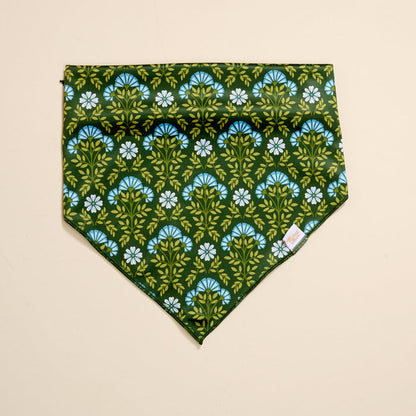 The Darling Effect Bow-Wow Pet Bandana-Everbloom Forest Green features a green base with blue and white flowers and green leaves—perfect as a stylish pet accessory or dog bandana.