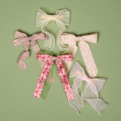 The-darling-effect’s Champagne Flower Scallop Hair Bow features sheer and lace finishes, pearls, strawberry prints, and gingham ribbon—perfect as a chic hair clip or stylish hair accessory for a charming look.