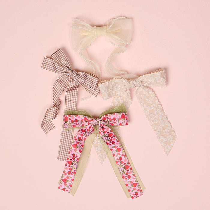 The-darling-effect’s Champagne Flower Scallop Hair Bow—shown with three other charming bows on a pink background—makes a cute accessory, featuring elegant scalloped edges and delicate floral details.