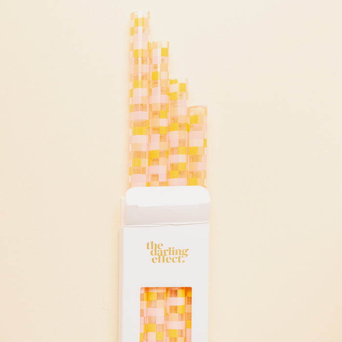 The Darling Effect Check Peach 40 oz Tumbler Straw Set features eco-friendly, reusable straws with a pink and yellow checkered pattern, packaged in a white box—perfect for your tumbler straw collection.