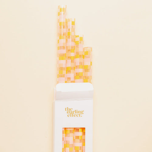 The Darling Effect Check Peach 40 oz Tumbler Straw Set features eco-friendly, reusable straws with a pink and yellow checkered pattern, packaged in a white box—perfect for your tumbler straw collection.