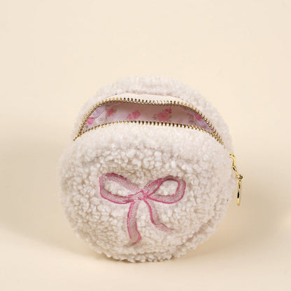 The Circle Bow Pink Teddy Pouch by the-darling-effect is a soft sherpa coin purse featuring a white, fluffy round design, pink embroidered bow, and floral lining.