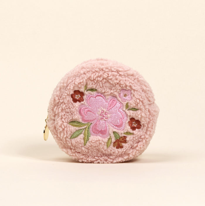 The Circle Dainty Floral Pink Teddy Pouch by the-darling-effect is a round, pink sherpa coin purse with embroidered pink and red flowers and green leaves on the front, plus a left-side zipper—an adorable accessory for your collection.