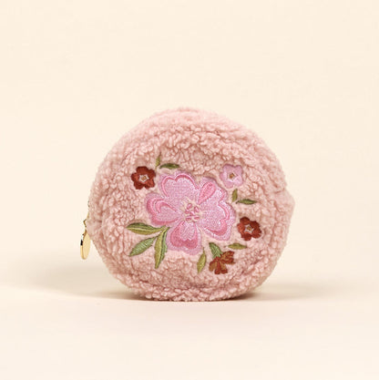 The Circle Dainty Floral Pink Teddy Pouch by the-darling-effect is a round, pink sherpa coin purse with embroidered pink and red flowers and green leaves on the front, plus a left-side zipper—an adorable accessory for your collection.