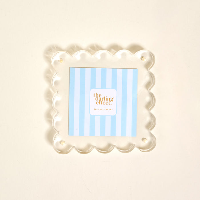 The Clear Square Scalloped Acrylic Frame by the-darling-effect features a blue and white striped insert with “the darling effect,” offering a modern, elegant display from the Scalloped Acrylic Picture Frames collection.
