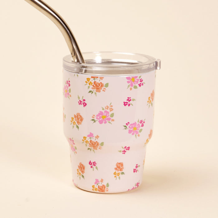 The Dainty Floral Pink 2 oz Tiny Tumbler by the-darling-effect is a white insulated mini tumbler featuring a clear lid, metal straw, and a dainty pattern of pink, orange, and yellow flowers on a light background.