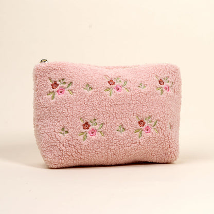 The Dainty Floral Pink Teddy Pouch by the-darling-effect features soft pink sherpa, embroidered pink and red flowers, and green leaves—a charming addition to our teddy pouches collection.