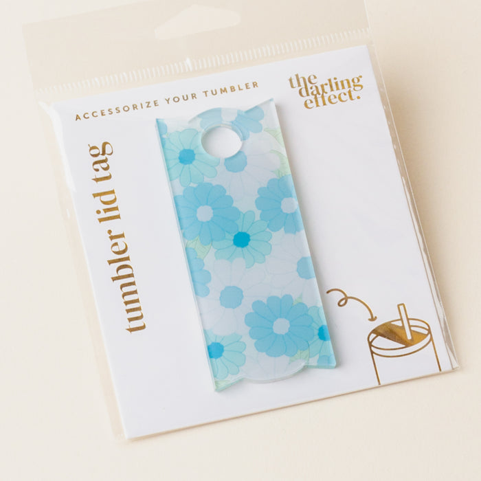 The Darling Effect's Daisy Craze Aqua Tumbler Lid Tag, featuring a blue floral design, is displayed on a white “Tumbler Lid Tag” card. Perfect for Stanley Quencher 2.0 lids, it adds fun flair to your personalized tumbler collection.