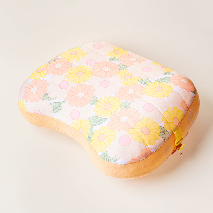 The Darling Effect's Daisy Craze Peach Ballast Beach Pillow is a limited-edition, puffy kidney-shaped pillow featuring a retro pink, peach, and yellow daisy floral pattern on cream—perfect for relaxing in style at the beach.