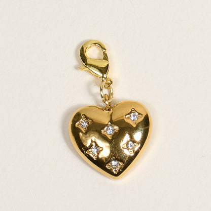 The Darling Effect Diamond Heart Jewelry Charm Gold features a gold heart design with five star-set clear gemstones and a lobster clasp, perfect for your charm bar. This piece adds elegance and meaning to your jewelry collection.