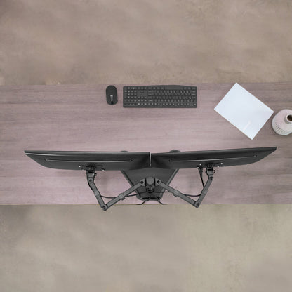 Desk setup with dual monitor, keyboard, mouse, and paper on a wooden desk.