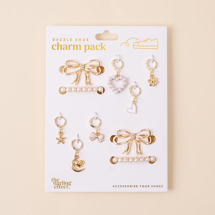 The Fancy Flair Dazzle Shoe Charm Pack by the-darling-effect includes 8 gold charms—bows, pearls, a moon, star, hearts, and a teddy bear—each with loops to easily accessorize your favorite sneakers or shoes.