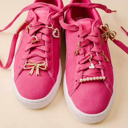 Add a fun twist to your bright pink sneakers with white soles using the-darling-effect’s Fancy Flair Dazzle Shoe Charm Pack, featuring gold bow, heart, star, and crescent moon charms plus delicate pearl lace accents.