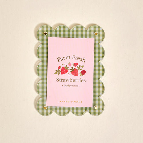 The Darling Effect Farm Fresh Strawberries Mini Acrylic Picture Frame Magnet features a green and white checkered scalloped border and displays a "Farm Fresh Strawberries" card with strawberry illustrations on a pink background.