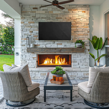 Outdoor patio with stone fireplace, TV, and wicker chairs and TV with protective cover.