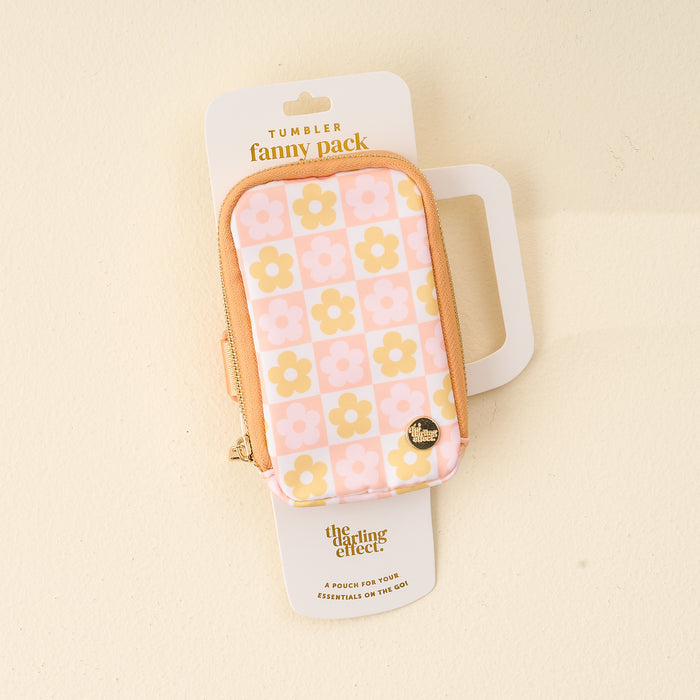 The Darling Effect's Flower Check Peach Tumbler Fanny Pack features a pink, peach, and yellow floral design, a water-resistant zippered pouch with a "Home" pin, and comes packaged as the Tumbler Fanny Pack.