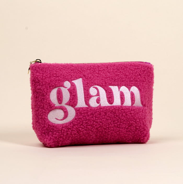 The Glam Teddy Pouch by the-darling-effect is a fluffy, hot pink sherpa cosmetic bag with "glam" embroidered in white, ideal for organizing your accessories or teddy pouches.