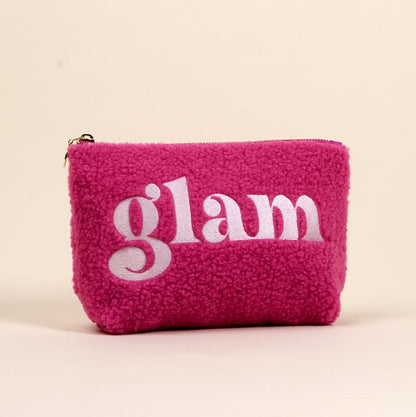 The Glam Teddy Pouch by the-darling-effect is a fluffy, hot pink sherpa cosmetic bag with "glam" embroidered in white, ideal for organizing your accessories or teddy pouches.