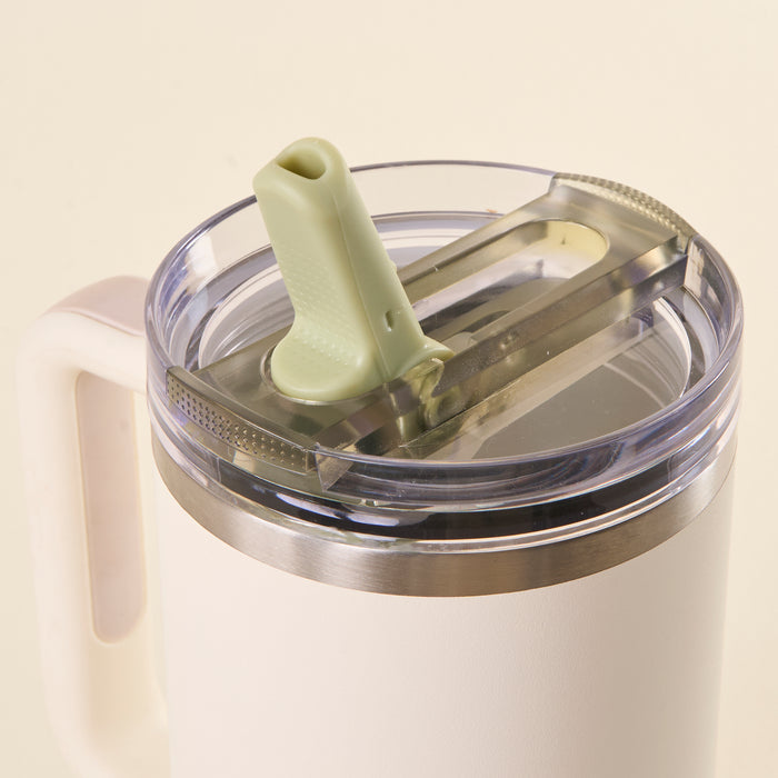 A close-up of the-darling-effect’s Green 40 oz Lifestyle Flip Straw Lid mug shows its white insulated body, handle, metal rim, leak-resistant flip straw lid with transparent cover, and green silicone straw—ideal for on-the-go hydration.