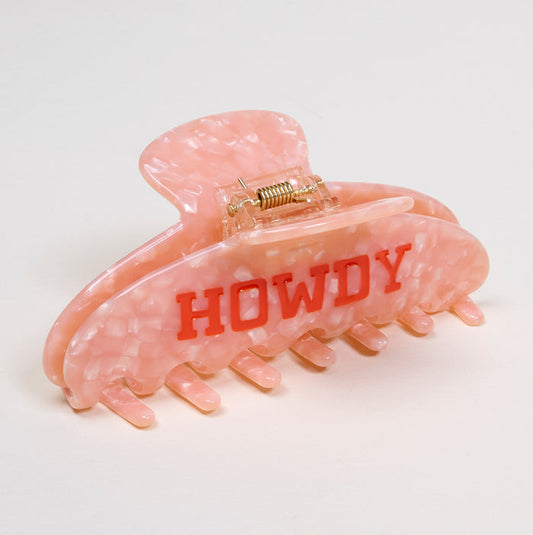 The Darling Effect’s Howdy Word Up Claw Clip features a pink marble pattern and bold red HOWDY letters, bringing standout style to any look.
