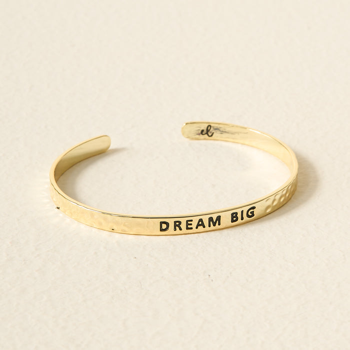 The Darling Effect's Little Reminder Cuff is a 14k gold adjustable bracelet stamped with "DREAM BIG"—a daily inspiration you can wear.