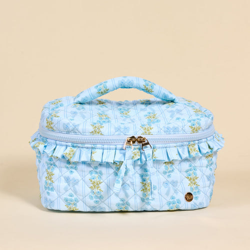 The Darling Effect's Oh So Fancy Blue Glam & Go Quilted Cosmetic Bag features a ruffled trim and gold zipper—perfect for stylishly organizing your essentials as a chic travel makeup bag.