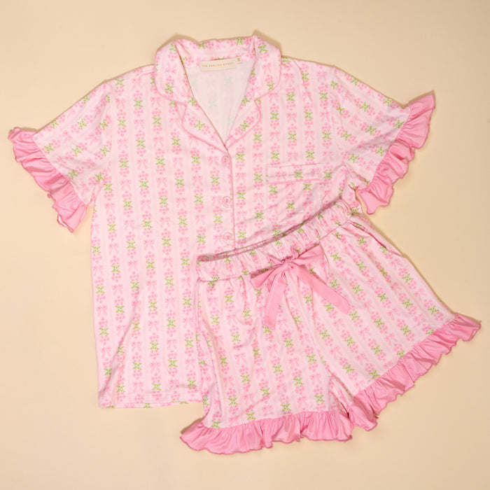 The Darling Effect's Oh So Fancy Pink Slumber Party Pajama Shorts Set features a satin-like, ultra-soft fabric, light pink floral pattern, ruffled edges, button-up top and matching shorts—perfect for relaxing nights.