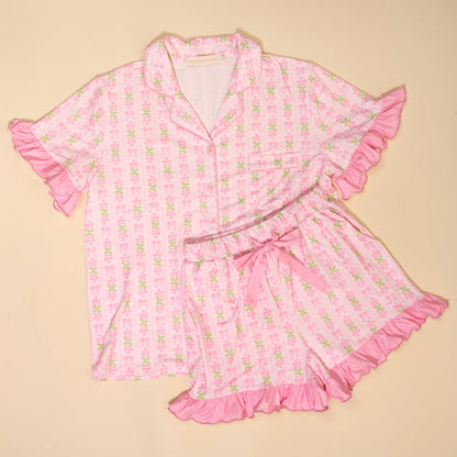 The Darling Effect's Oh So Fancy Pink Slumber Party Pajama Shorts Set features a satin-like, ultra-soft fabric, light pink floral pattern, ruffled edges, button-up top and matching shorts—perfect for relaxing nights.