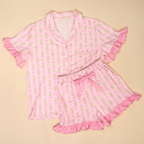 The Darling Effect's Oh So Fancy Pink Slumber Party Pajama Shorts Set features a satin-like, ultra-soft fabric, light pink floral pattern, ruffled edges, button-up top and matching shorts—perfect for relaxing nights.