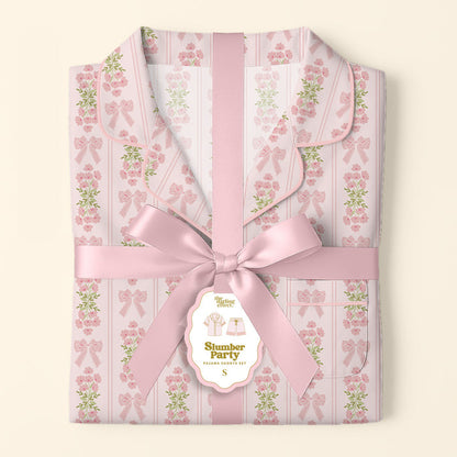 The Darling Effect’s Oh So Fancy Pink Slumber Party Pajama Shorts Set features a floral and bow pattern, ultra-soft fabric, and arrives gift-ready with a pink satin ribbon and a tag reading "Slumber Party Pajama Gift Set.
