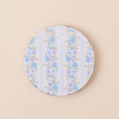 The-darling-effect’s Petal Parade Blue Wood Enamel Coaster features blue and purple floral designs with green leaves on white and light blue stripes—a stylish, durable addition to your coaster collection.