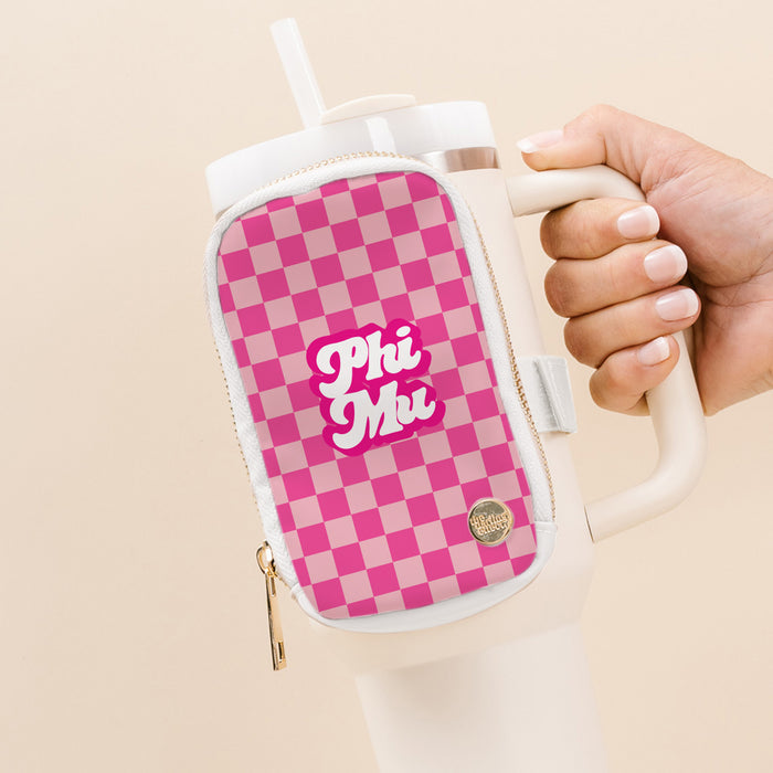 A hand holds The Darling Effect’s Phi Mu Tumbler Fanny Pack, a white tumbler with a pink checkered water-resistant pouch, "Phi Mu" in bold white letters, and a small round gold logo by the zipper.